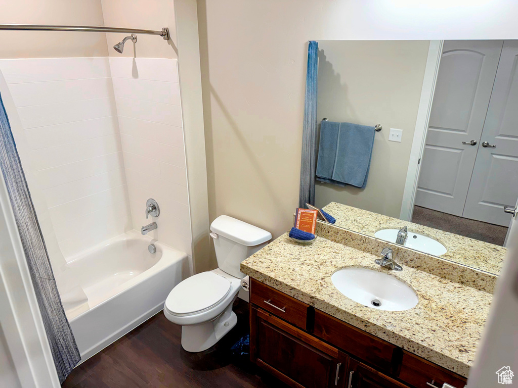 Bathroom with washtub / shower combination, wood finished floors, and vanity
