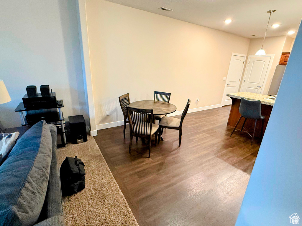Dining space with dark wood-style floors and recessed lighting