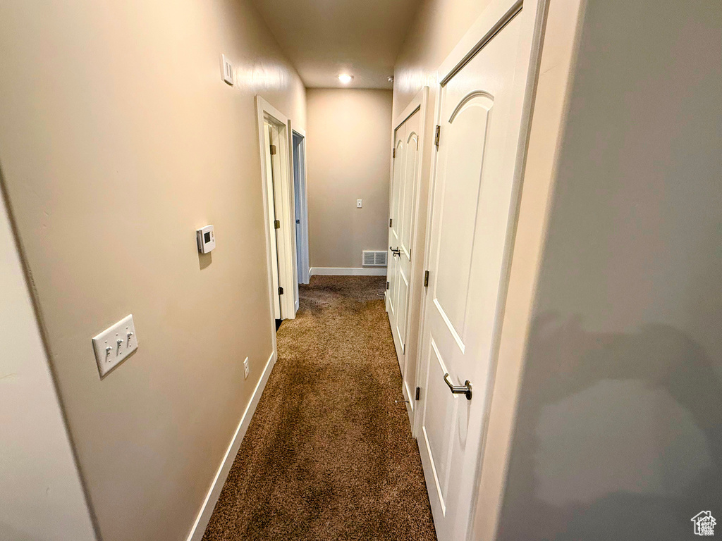 Hall with dark colored carpet and recessed lighting