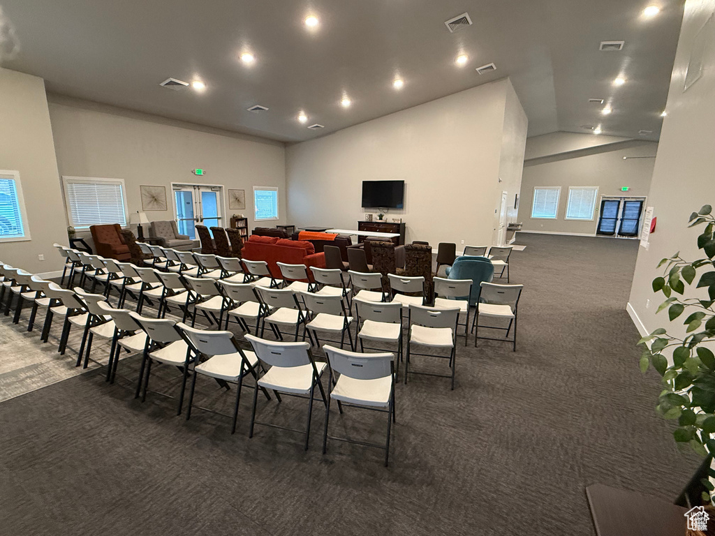 Misc room with dark carpet, high vaulted ceiling, and recessed lighting