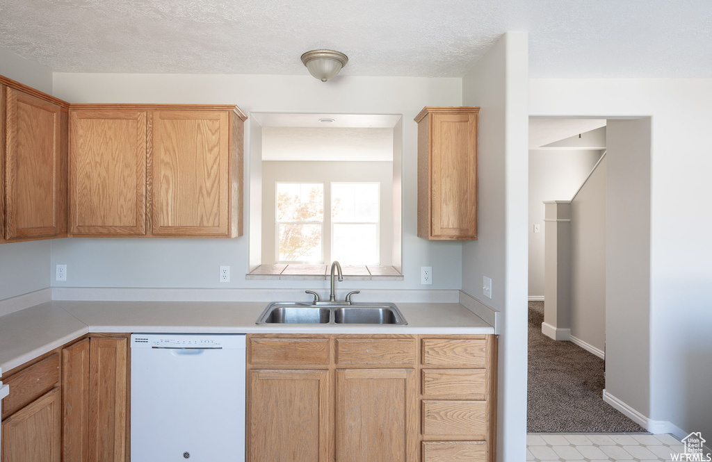 Kitchen with white dishwasher and light countertops