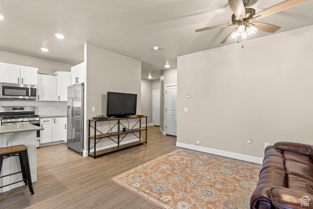 Living area with ceiling fan, recessed lighting, and light wood-type flooring