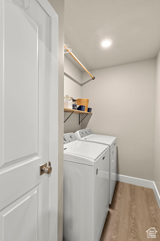 Washroom with separate washer and dryer, light wood-type flooring, and recessed lighting