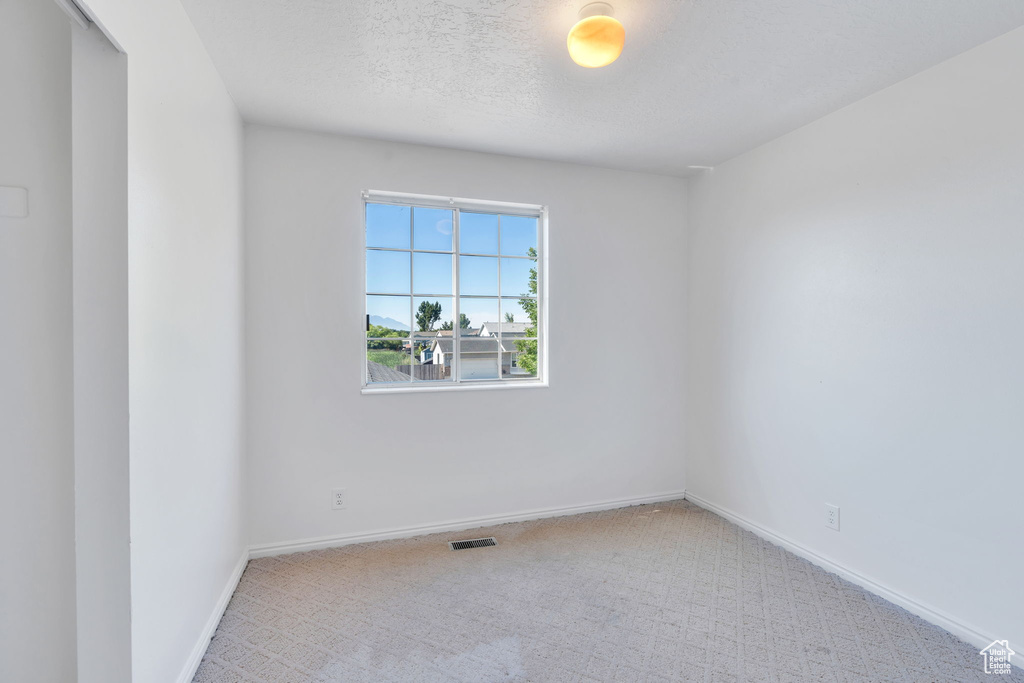Carpeted empty room featuring baseboards