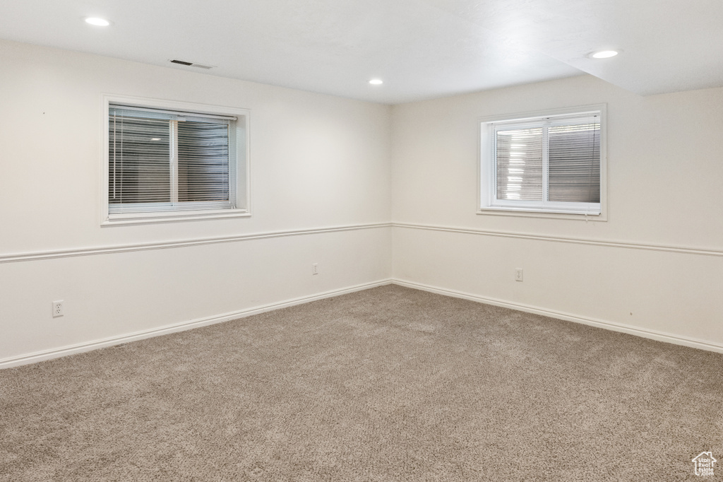 Carpeted spare room featuring baseboards and recessed lighting