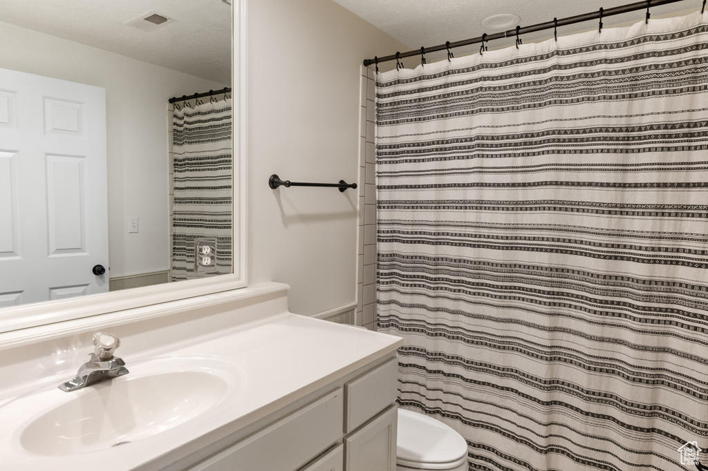 Full bath with vanity and a shower with shower curtain