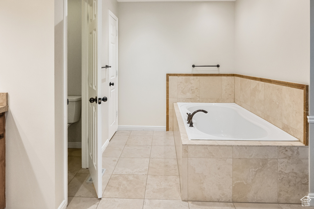 Bathroom with a bath, vanity, and tile patterned flooring