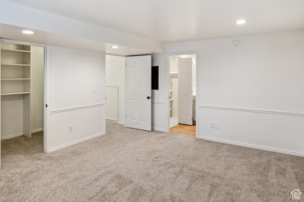 Unfurnished bedroom with carpet flooring, a walk in closet, recessed lighting, and ensuite bath