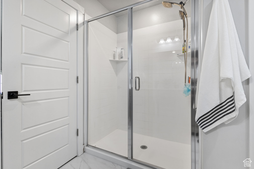 Bathroom featuring a stall shower and marble finish flooring