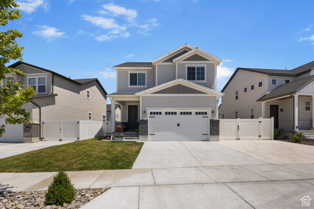 Craftsman-style house featuring a gate, driveway, and an attached garage