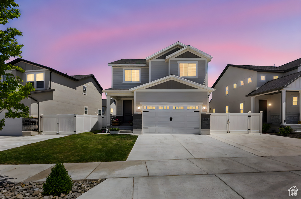 Craftsman house featuring a gate, driveway, and an attached garage