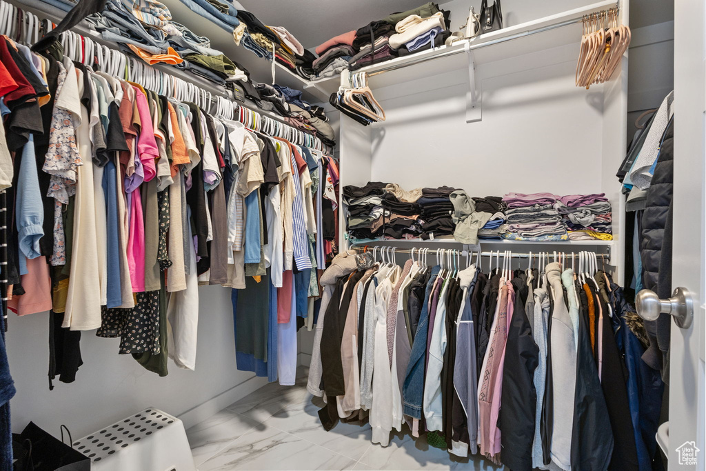 Walk in closet with marble look tile flooring