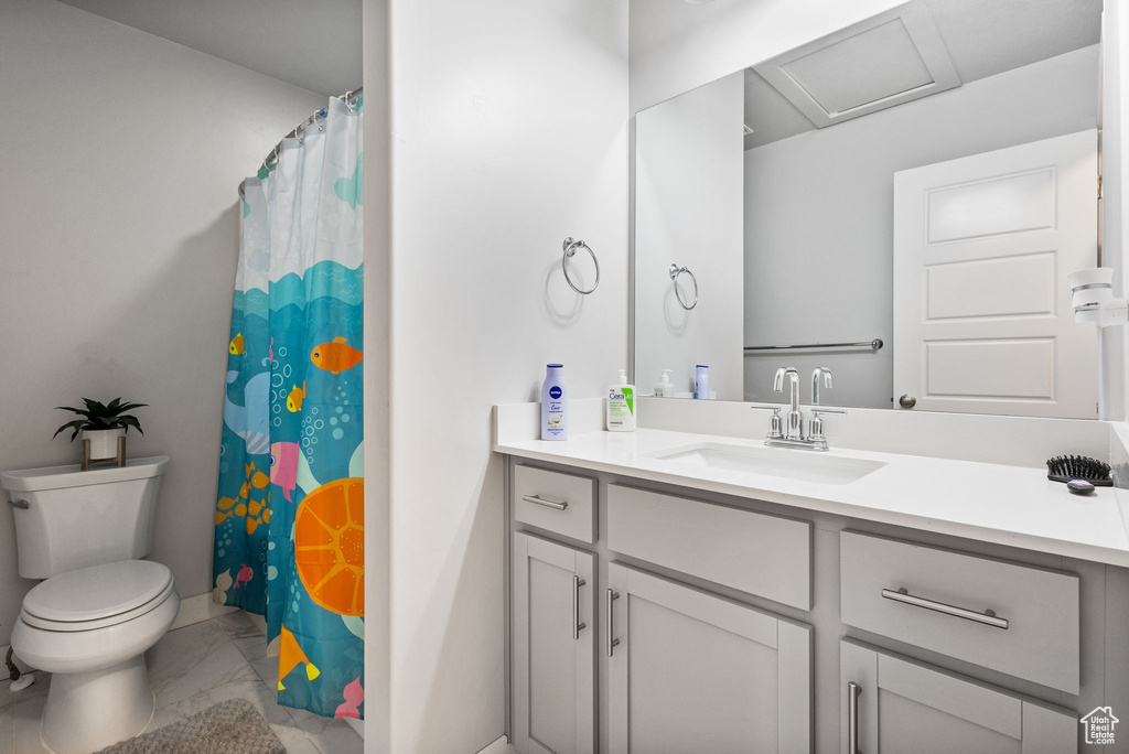 Bathroom featuring marble look tile flooring, vanity, and a shower with shower curtain