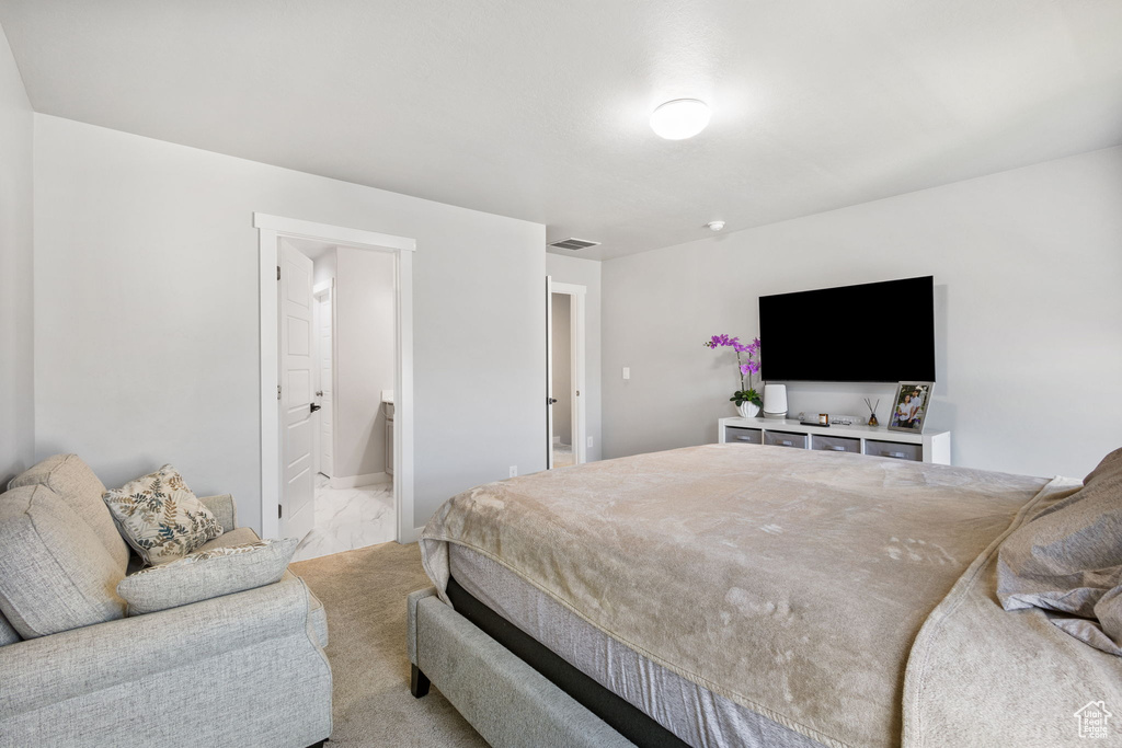 Bedroom featuring light marble finish flooring and ensuite bath