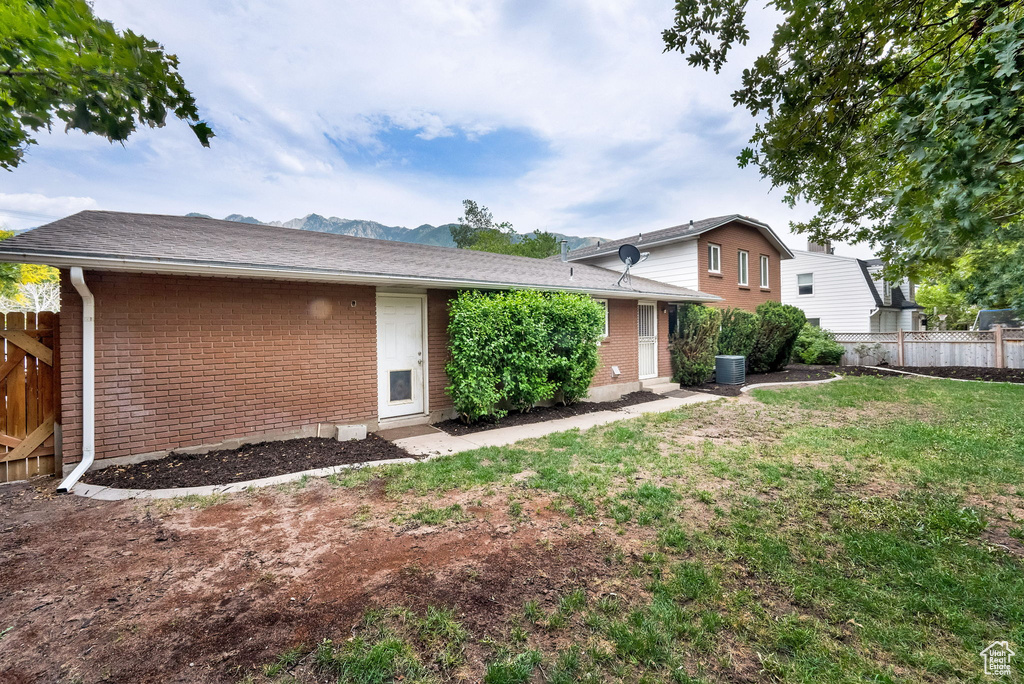 View of front of home with brick siding, a mountain view, and entry steps