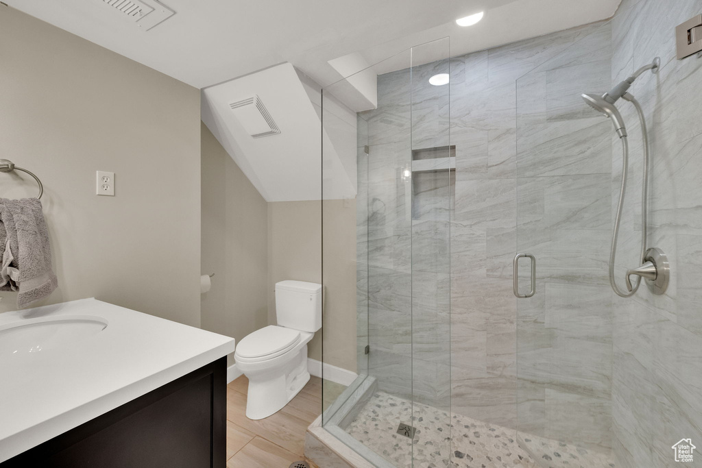 Full bath with vanity, wood finished floors, a stall shower, and recessed lighting