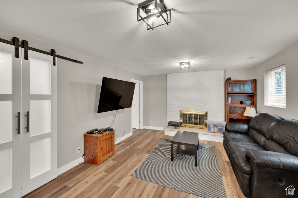 Living area featuring a barn door and light wood-style flooring