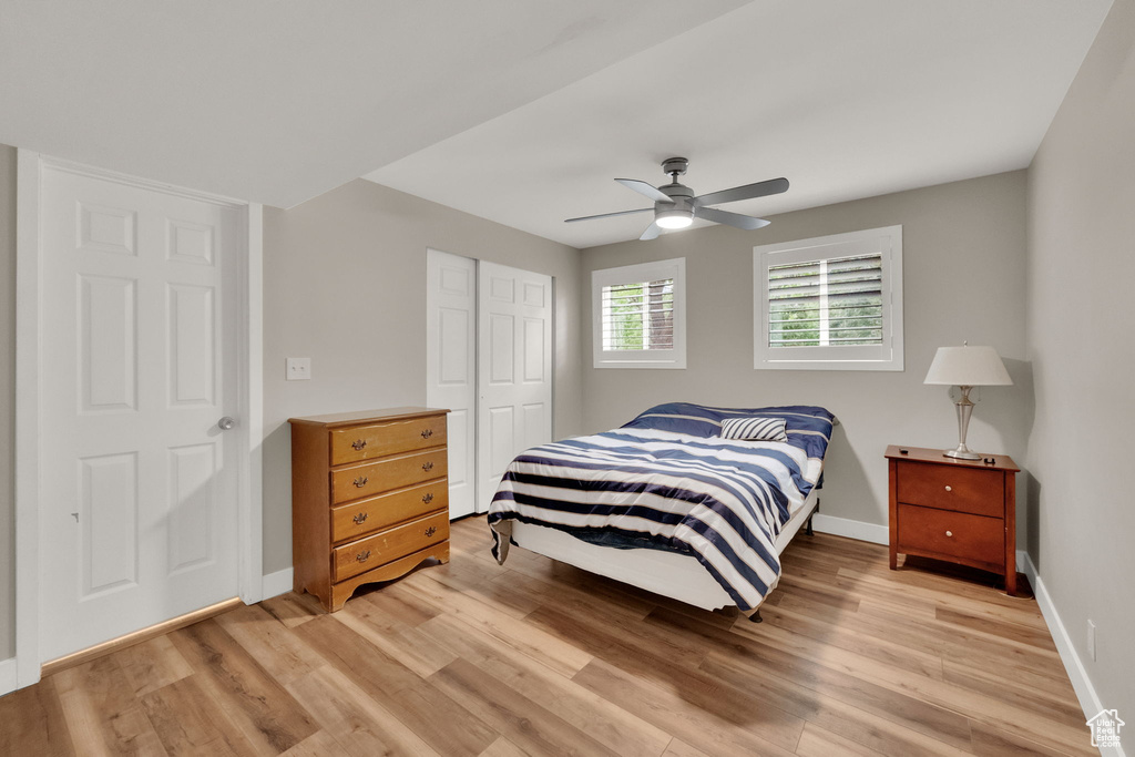 Bedroom featuring light wood-style flooring, a closet, and a ceiling fan