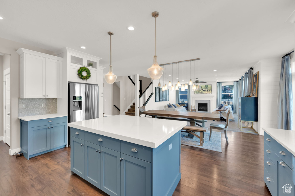 Kitchen featuring open floor plan, blue cabinetry, a fireplace, light countertops, and white cabinets