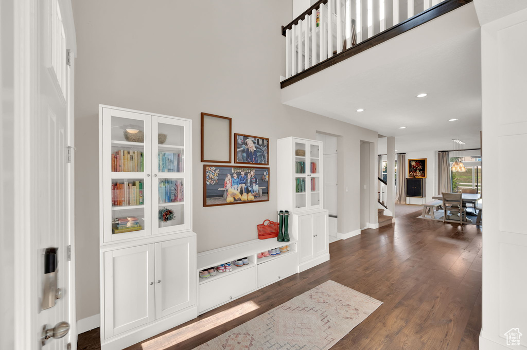 Foyer featuring dark wood-style flooring, a towering ceiling, and recessed lighting