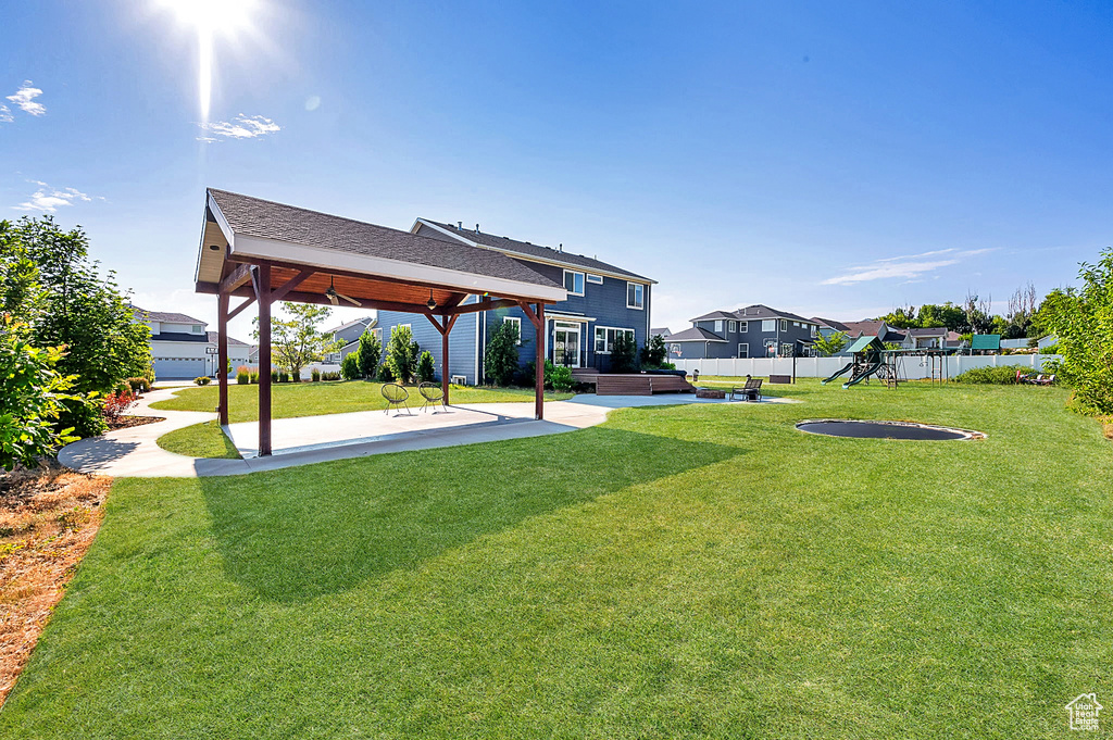 View of yard with a hot tub, a patio, a playground, and a gazebo