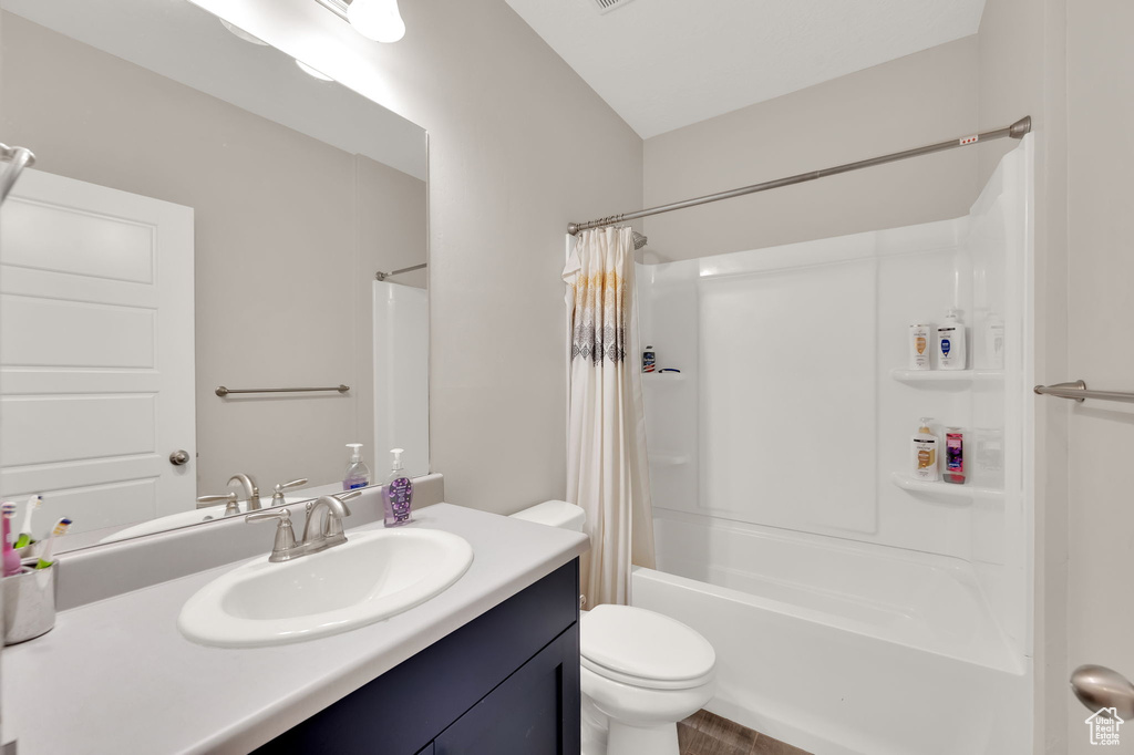 Bathroom featuring vanity and shower / bathtub combination with curtain