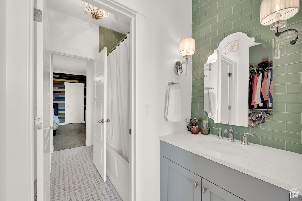 Bathroom featuring vanity, shower / bath combination with curtain, and a closet
