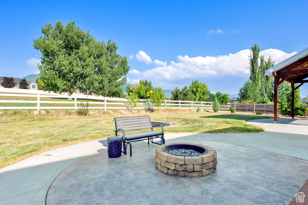 Fenced backyard with an outdoor fire pit and a patio
