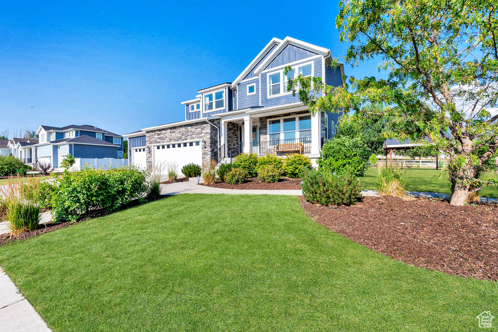 Craftsman house with stone siding, board and batten siding, concrete driveway, and an attached garage