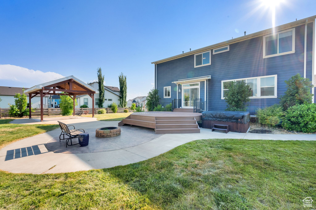 Rear view of property with an outdoor fire pit, a gazebo, a patio area, and a lawn