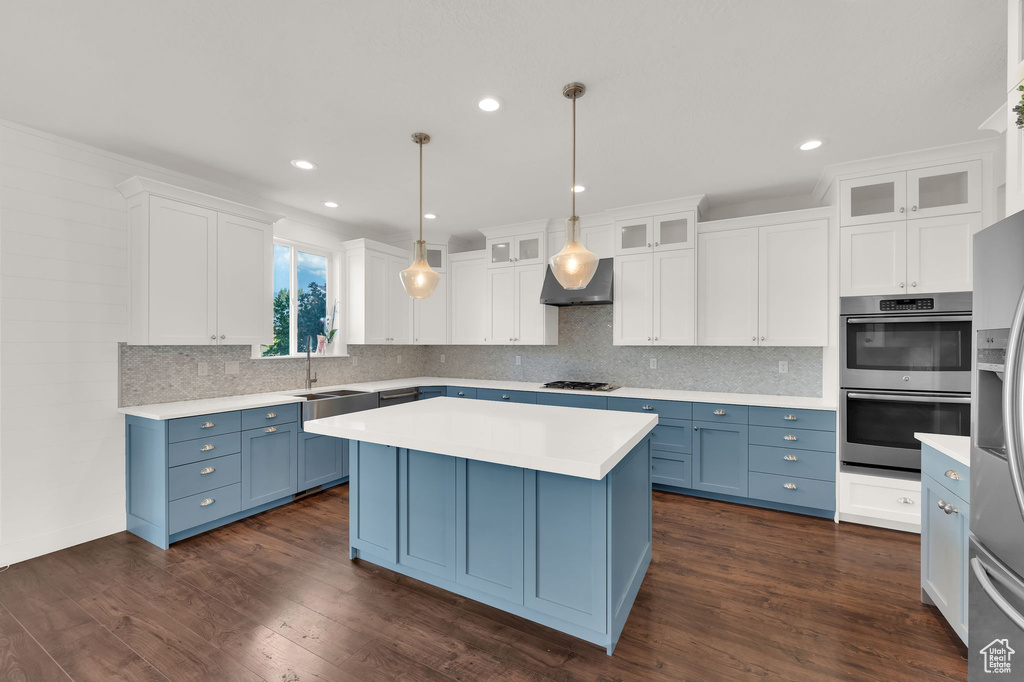 Kitchen featuring blue cabinets, white cabinets, light countertops, tasteful backsplash, and recessed lighting