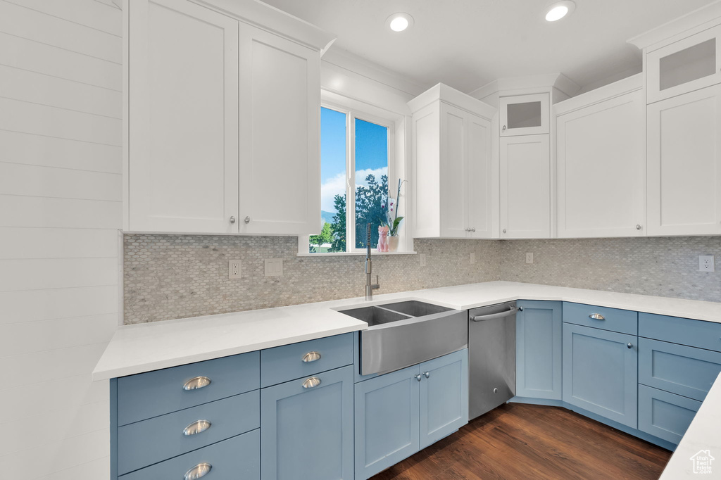 Kitchen featuring blue cabinets, light countertops, stainless steel dishwasher, and recessed lighting