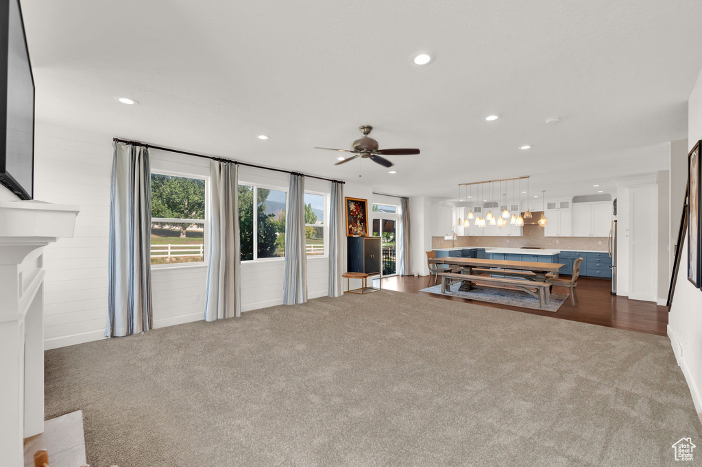 Living room featuring dark carpet, plenty of natural light, recessed lighting, and a ceiling fan