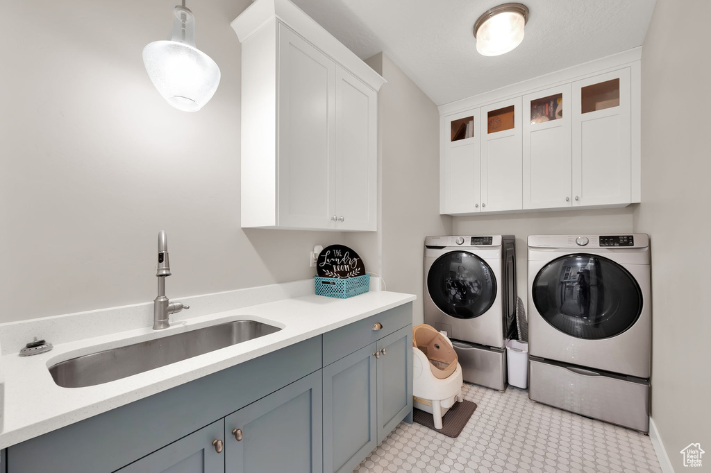 Laundry area featuring cabinet space, washing machine and clothes dryer, and light floors