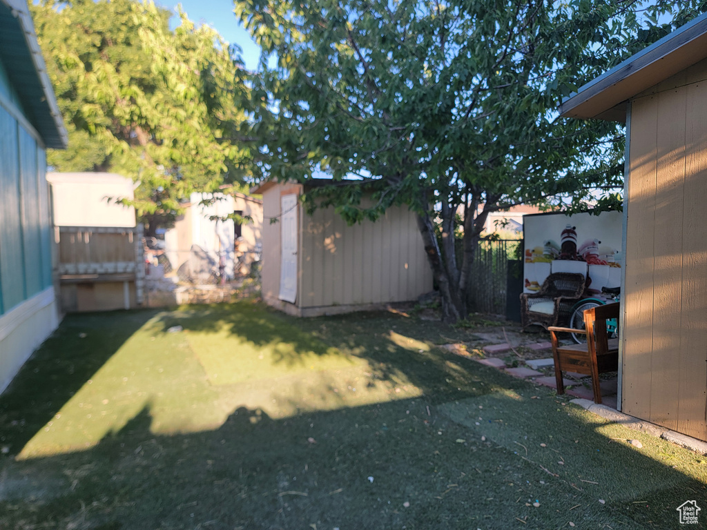 Fenced backyard featuring a shed