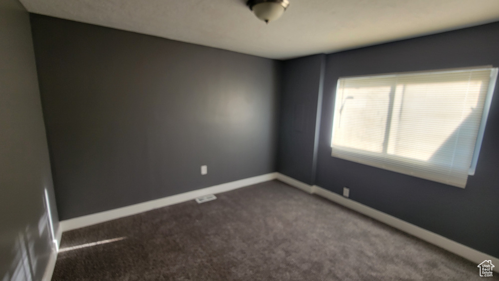 Carpeted spare room with baseboards
