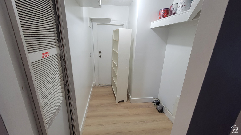 Laundry room featuring light wood finished floors and a heating unit