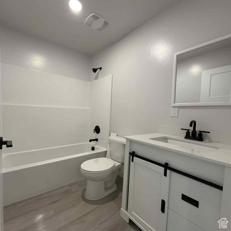 Bathroom with vanity, shower / tub combination, and wood finished floors