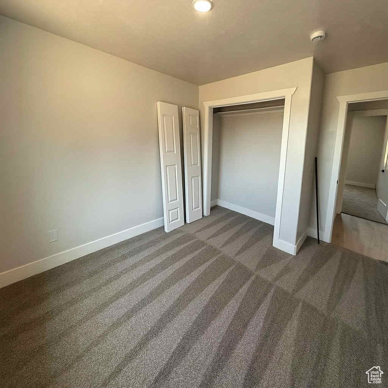 Unfurnished bedroom featuring carpet and a closet
