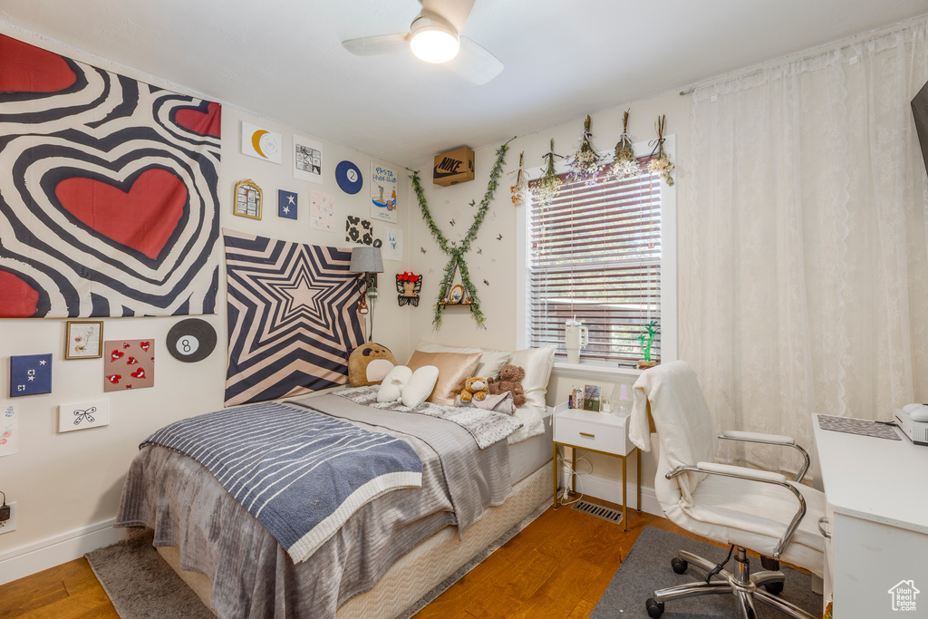 Bedroom featuring wood finished floors, ceiling fan, and a desk
