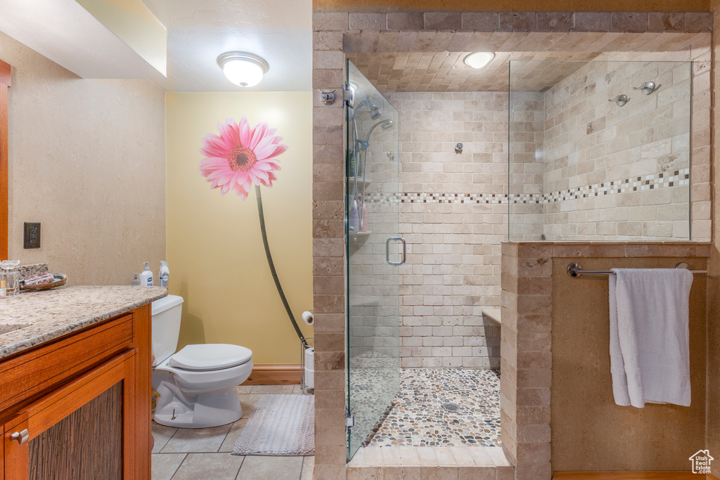 Full bathroom featuring a shower stall, tile patterned floors, and vanity