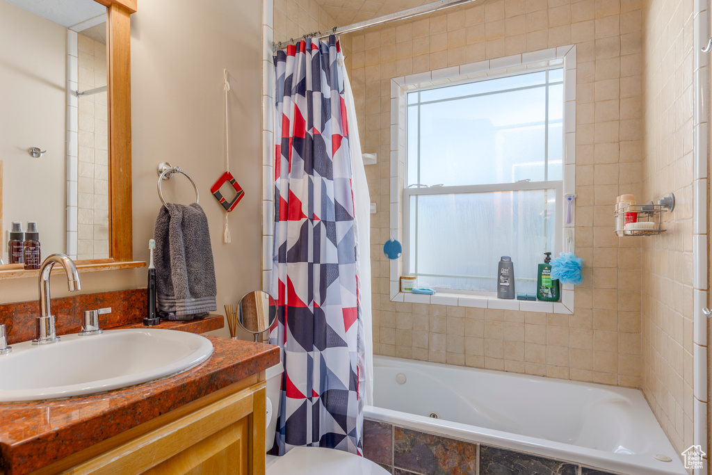 Bathroom with tiled shower / bath combo and vanity