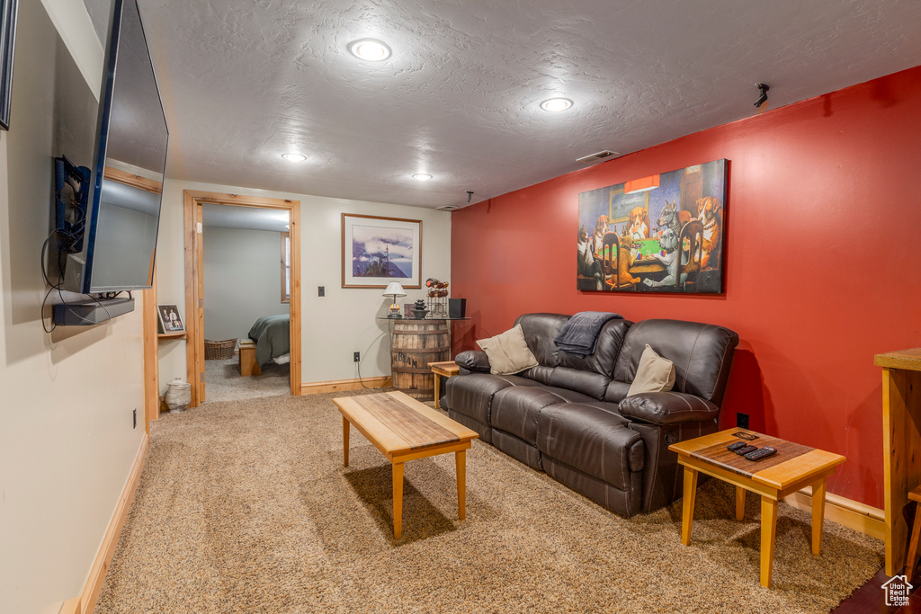 Living room featuring carpet floors, recessed lighting, and a textured ceiling