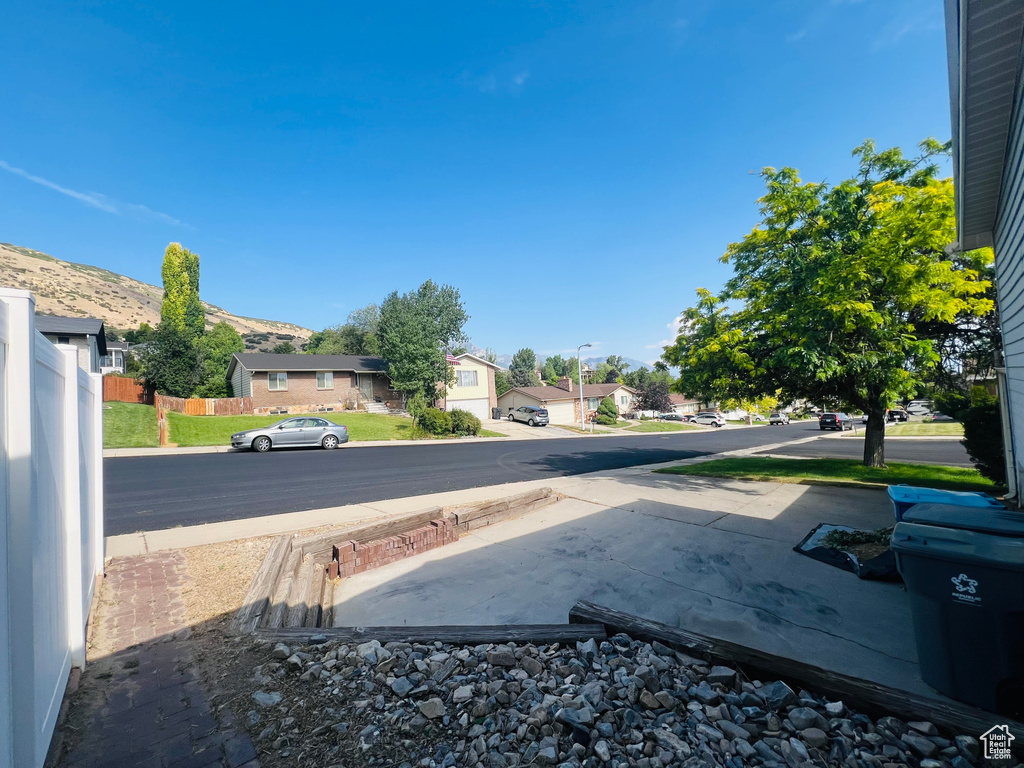 View of asphalt street featuring street lighting, a residential view, and sidewalks