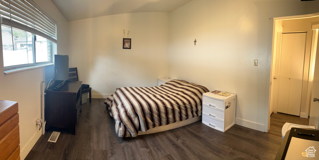 Bedroom with dark wood-style flooring and vaulted ceiling