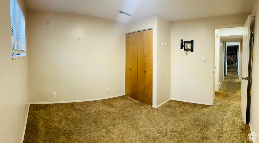 Unfurnished bedroom featuring carpet flooring and a closet