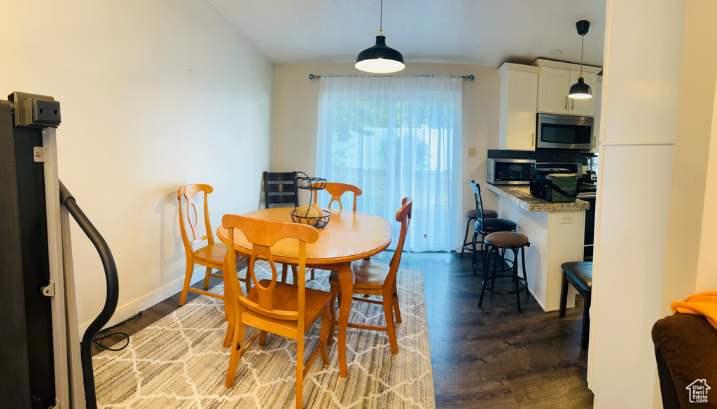 Dining area with wood finished floors and lofted ceiling