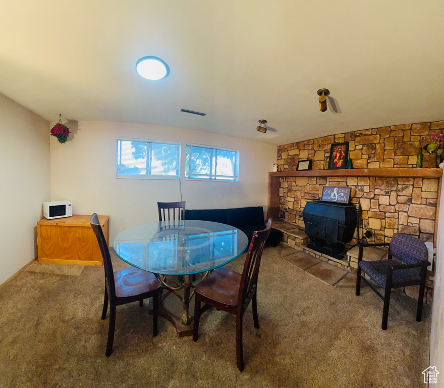 Dining area featuring carpet floors and a wood stove