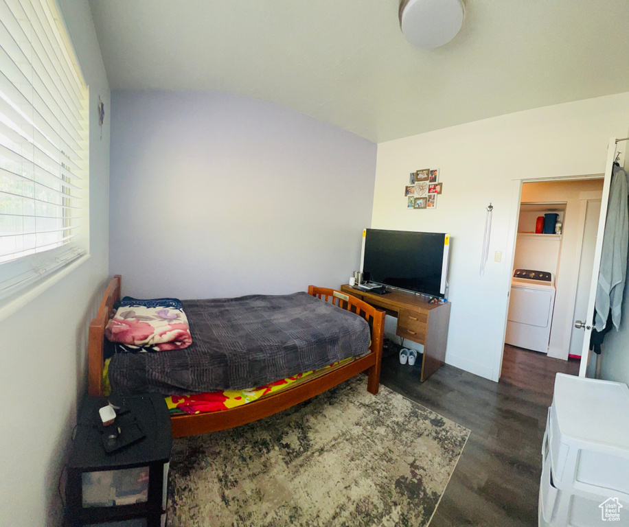 Bedroom with washer / clothes dryer and dark wood finished floors