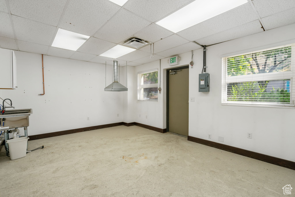 Basement with a drop ceiling and electric panel